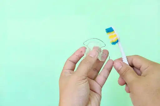 Properly brushing a clear retainer to remove plaque and maintain retainer hygiene
