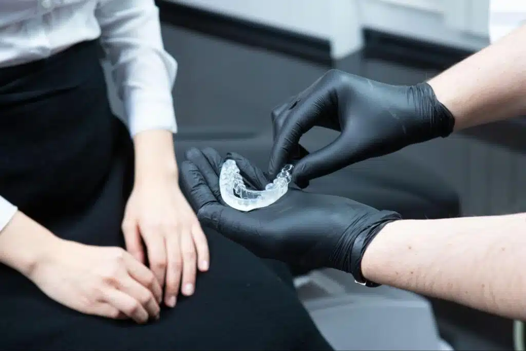 Orthodontist showing sports mouthguard options for children